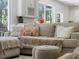 Comfortable living area with stylish pillows, a cozy blanket, and natural light through large windows at 678 Clear Creek Dr, Osprey, FL 34229