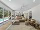 Open-concept living space flowing to the outdoor pool area, wood floors, and modern décor at 678 Clear Creek Dr, Osprey, FL 34229