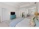 Spacious bedroom with tray ceiling, complemented by a blue dresser and light-filled dressing table area at 678 Clear Creek Dr, Osprey, FL 34229