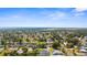 Wide aerial shot of homes, trees, and an airport runway on a bright day with blue sky at 755 Mohawk Rd, Venice, FL 34293