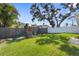 Fenced backyard with a grassy lawn, play set, and mature trees providing shade at 755 Mohawk Rd, Venice, FL 34293