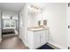 Bright bathroom with granite countertop, white vanity, wood-look tile floors, and a framed mirror at 755 Mohawk Rd, Venice, FL 34293