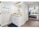 Bright bathroom with granite countertop, white vanity, wood-look tile floors, and a framed mirror at 755 Mohawk Rd, Venice, FL 34293