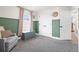Bright bedroom featuring a cozy armchair, blue storage bench, and neutral carpet at 755 Mohawk Rd, Venice, FL 34293