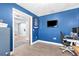 Stylish home office with blue accent wall, desk, and view to main living area at 755 Mohawk Rd, Venice, FL 34293