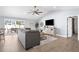 Bright living room with vaulted ceiling, sliding glass doors to lanai, and barn door at 755 Mohawk Rd, Venice, FL 34293