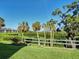 Scenic backyard view featuring lush greenery, palm trees, and tranquil waterfront scenery at 821 Waterside Dr # 106, Venice, FL 34285