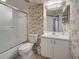 A bathroom with white vanity, tub and shower, and decorated in floral wallpaper at 821 Waterside Dr # 106, Venice, FL 34285
