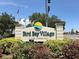 Bird Bay Village: A Golf Community sign with an American flag and lush foliage surrounding the base at 821 Waterside Dr # 106, Venice, FL 34285