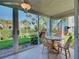 Eat-in dining area with a wood table, tiled floor, ceiling fan and sliding glass doors to the outside at 821 Waterside Dr # 106, Venice, FL 34285
