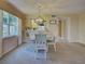 View of the dining room, showing a chandelier fixture, a window, and the living room pass through at 821 Waterside Dr # 106, Venice, FL 34285