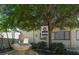 Exterior shot of fitness room with a water fountain and bench by a lush tree at 821 Waterside Dr # 106, Venice, FL 34285