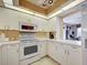 Bright kitchen with white cabinets, modern appliances and tile flooring at 821 Waterside Dr # 106, Venice, FL 34285