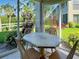 Cozy lanai area featuring a charming table set and scenic views of lush greenery at 821 Waterside Dr # 106, Venice, FL 34285