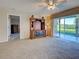 Bright living room with a sliding glass door, neutral carpet, and a large entertainment center at 821 Waterside Dr # 106, Venice, FL 34285