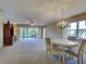Spacious living room features plush carpet, sliding glass doors to a patio and a ceiling fan at 821 Waterside Dr # 106, Venice, FL 34285
