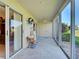 Enclosed tiled patio with a sliding glass doors, neutral colors, ceiling fan, and outdoor furniture at 821 Waterside Dr # 106, Venice, FL 34285