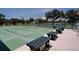 Shuffleboard courts with green benches and pickleball/tennis courts in the background for recreation at 821 Waterside Dr # 106, Venice, FL 34285