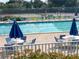 Community pool area with chairs and tables around a sparkling blue pool at 821 Waterside Dr # 106, Venice, FL 34285