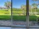 Balcony view showcasing a picturesque waterfront scene with lush greenery and swaying palm trees at 821 Waterside Dr # 106, Venice, FL 34285