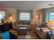 Inviting living room with two sofas, wood floors, and an abundance of natural light from the many windows at 902 Jolanda Cir, Venice, FL 34285