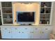 Living room with a TV surrounded by built-in shelves and storage cabinets at 902 Jolanda Cir, Venice, FL 34285
