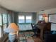 Well-lit home office with wood floors, a comfortable futon, and a vintage secretary desk at 902 Jolanda Cir, Venice, FL 34285