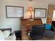 Cozy home office area with a vintage secretary desk, framed artwork, and comfortable armchair seating at 902 Jolanda Cir, Venice, FL 34285