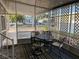A well-lit screened-in porch holds a decorative table and chairs, carpet, and a view of the outdoors at 902 Jolanda Cir, Venice, FL 34285