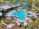 Expansive aerial view of the community pool, spa, and clubhouse surrounded by lush greenery and serene lakes at 9048 Luna Ln, Sarasota, FL 34241