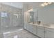 Elegant bathroom showcasing double vanities and an open walk-in shower with marble tile at 9048 Luna Ln, Sarasota, FL 34241