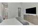Bedroom with a light dresser, TV, bright walls, and a comforter with gray accents at 9048 Luna Ln, Sarasota, FL 34241
