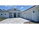 Stunning home featuring a paver driveway leading to a three-car garage, and meticulously landscaped front yard at 9048 Luna Ln, Sarasota, FL 34241
