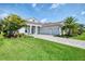 Well-manicured lawn and driveway leading to a gray home with a three-car garage at 9048 Luna Ln, Sarasota, FL 34241