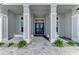 Grand entrance with double doors, framed by stately columns and complemented by a paver walkway and green landscaping at 9048 Luna Ln, Sarasota, FL 34241