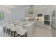 Modern kitchen with a large island featuring barstool seating and updated stainless steel appliances at 9048 Luna Ln, Sarasota, FL 34241