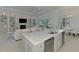 Open kitchen view from the island offering seating space and stainless steel appliances, and views into the living room at 9048 Luna Ln, Sarasota, FL 34241