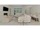 Spacious living room with modern decor, fireplace, large windows, and connecting views into the kitchen and outdoor pool area at 9048 Luna Ln, Sarasota, FL 34241