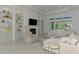 Bright, open living room with built-in shelving, fireplace, and a large window offering picturesque outdoor views at 9048 Luna Ln, Sarasota, FL 34241