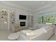 Bright living room featuring a fireplace, shelving, and large windows with lush views at 9048 Luna Ln, Sarasota, FL 34241