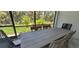 Enclosed outdoor dining area with a view of lush greenery, perfect for enjoying meals in a private setting at 9048 Luna Ln, Sarasota, FL 34241