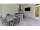 Outdoor kitchen with stainless steel appliances, bar seating, a grill, and a large dining table for entertaining at 9048 Luna Ln, Sarasota, FL 34241
