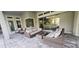 Inviting covered patio features stylish wicker furniture and a cozy fire pit for outdoor relaxation and entertaining at 9048 Luna Ln, Sarasota, FL 34241