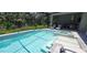 Sparkling pool and spa with sun shelves, lush landscaping, and private backyard at 9048 Luna Ln, Sarasota, FL 34241