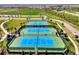 Aerial view of tennis and pickleball courts in a beautiful green space within the community at 9048 Luna Ln, Sarasota, FL 34241