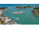 Stunning aerial view of turquoise waters, a passing boat, a secluded island, and waterfront homes at 976 Euclid Rd, Venice, FL 34293