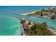 Coastal aerial of turquoise ocean waters meeting the shoreline, featuring jetties, beaches, and lush greenery at 976 Euclid Rd, Venice, FL 34293
