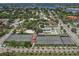 An aerial view shows multiple tennis and basketball courts in a scenic area surrounded by lush trees and neighborhood views at 976 Euclid Rd, Venice, FL 34293