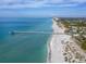 Aerial view of a pristine white sand beach, pier, and turquoise water, capturing the essence of coastal paradise at 976 Euclid Rd, Venice, FL 34293