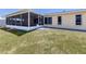 View of the backyard showcasing the screened lanai and well-maintained lawn at 976 Euclid Rd, Venice, FL 34293